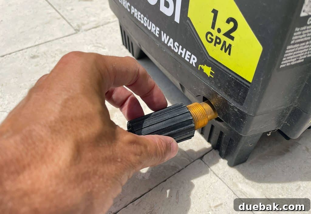 Essential Pressure Washer Tips For First Timers 5 Screwing high pressure hose to side of Ryobi Electric Pressure Washer