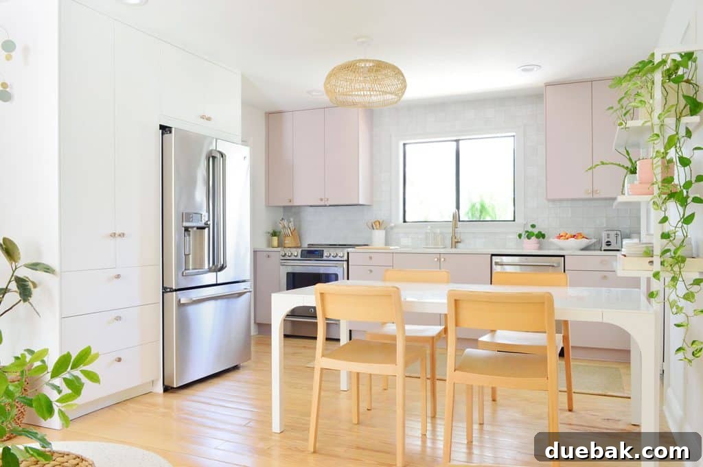Side view of the Ikea kitchen, featuring white and mauve cabinets, a long dining table, and natural light.