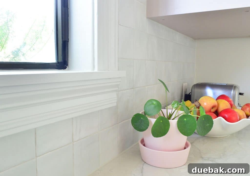 Close-up view of the textured gray zellige-style backsplash tile, showing its unique variations and subtle sheen.