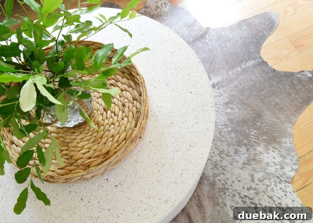 Overhead view of the CB2 terrazzo outdoor coffee table on a metallic cowhide rug, highlighting the textures.