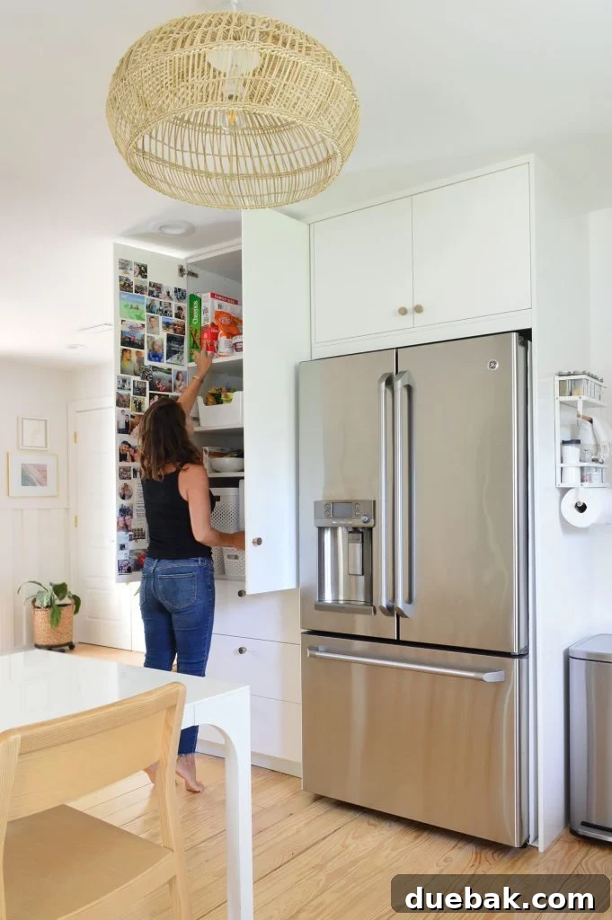 Sherry Standing In Front Of Open Ikea Pantry Cabinets Built To Ceiling