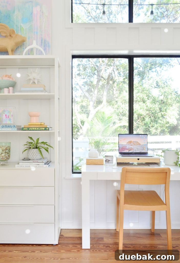 West Elm Parsons Desk in large picture window with Ikea Fjalkinge shelves