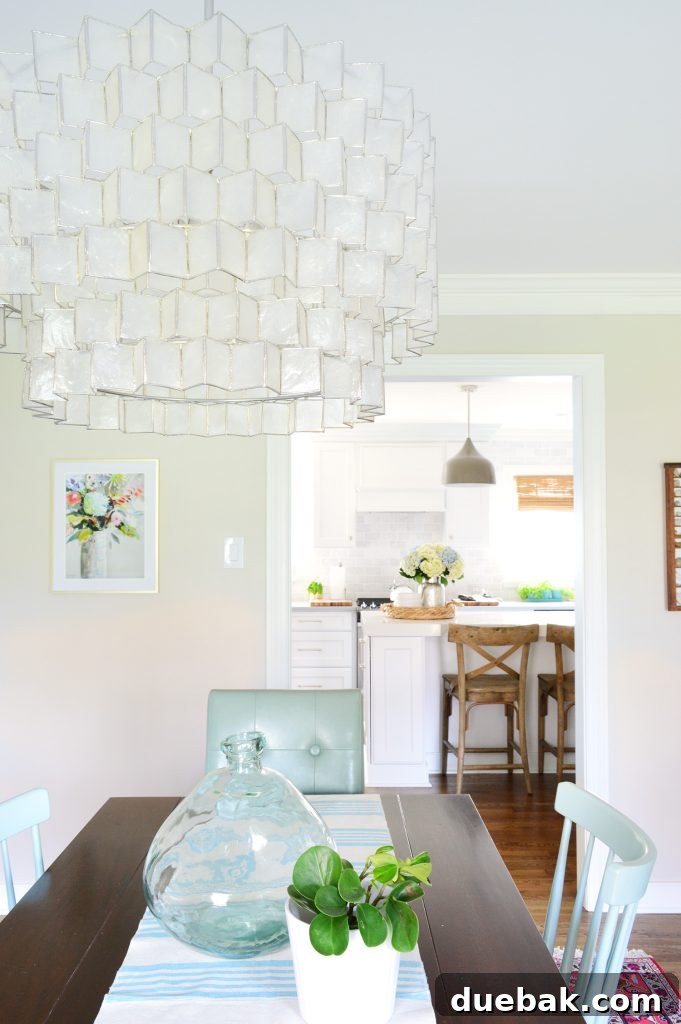 Capiz light fixture in dining room with large glass vase