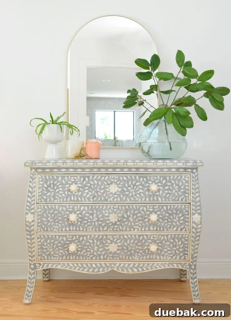 Blue and white inlay dresser with arch brass mirror and large plant vase