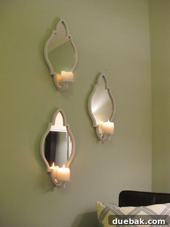 Completed bedroom wall with three ZGallerie mirrored sconces and a cozy bed