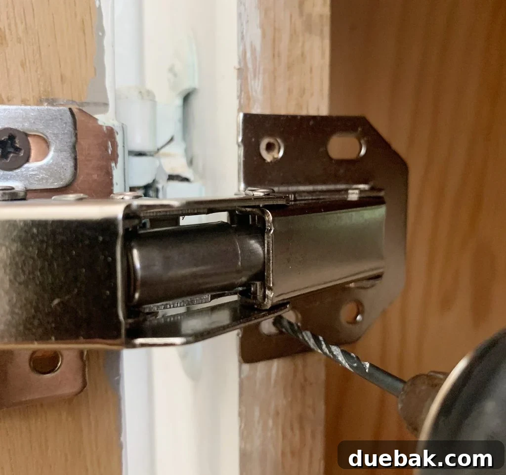 Upgrade Your Old Cabinets with Invisible Hinges 7 Drilling pilot hole through hidden cabinet hinge into cabinet frame