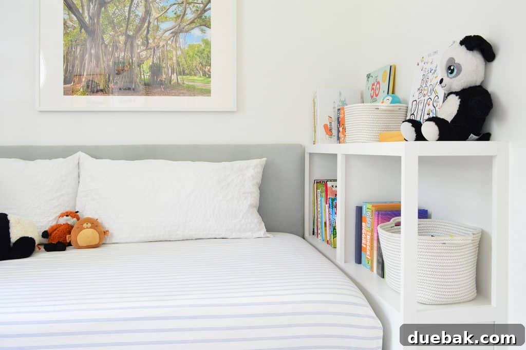 After photo of the completed built-in bookcase at the foot of the bed, neatly organized with a collection of books and stuffed animals, demonstrating its functional appeal and integrated design.