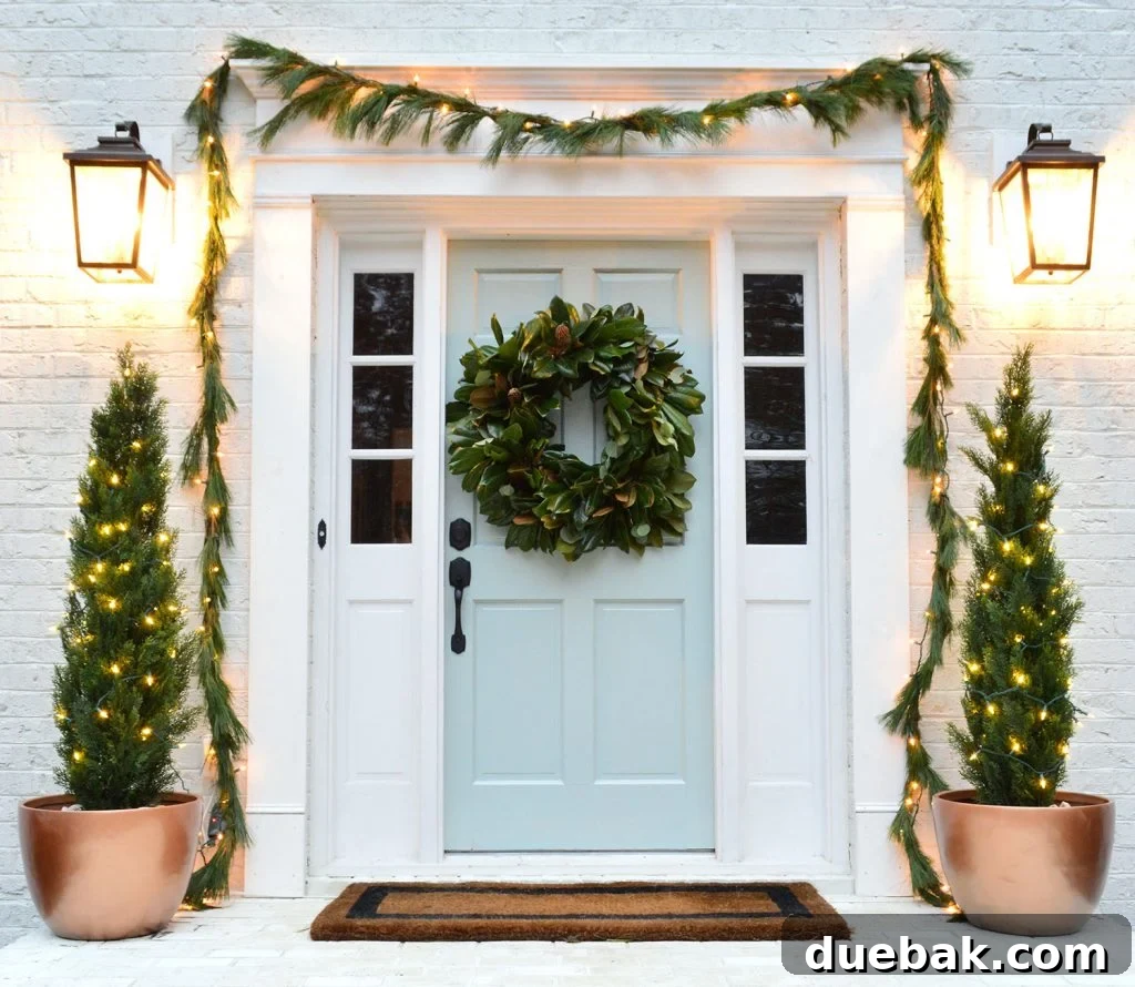 Holiday Front Porch Decorated with Lush Garland and Elegant Faux Evergreen Trees