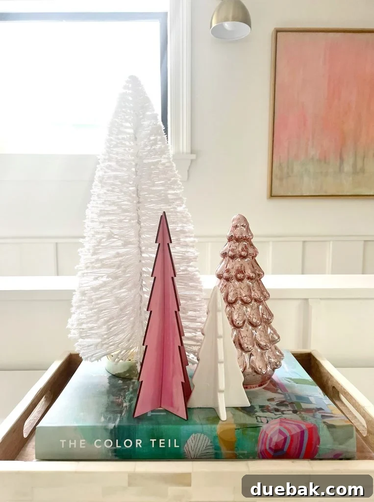 A charming assortment of small tabletop decorative Christmas trees, including bottlebrush, wooden, ceramic, and mercury glass styles, arranged for a festive display.