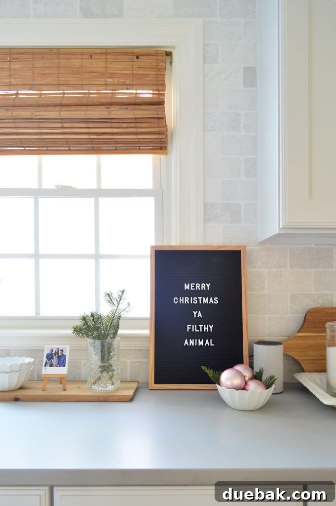 A stylish black letterboard on a kitchen counter displaying the humorous holiday message 