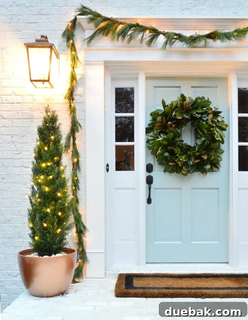 A festive holiday front porch adorned with lush garland and elegant faux trees in stunning copper-painted pots, creating a warm and inviting entrance.