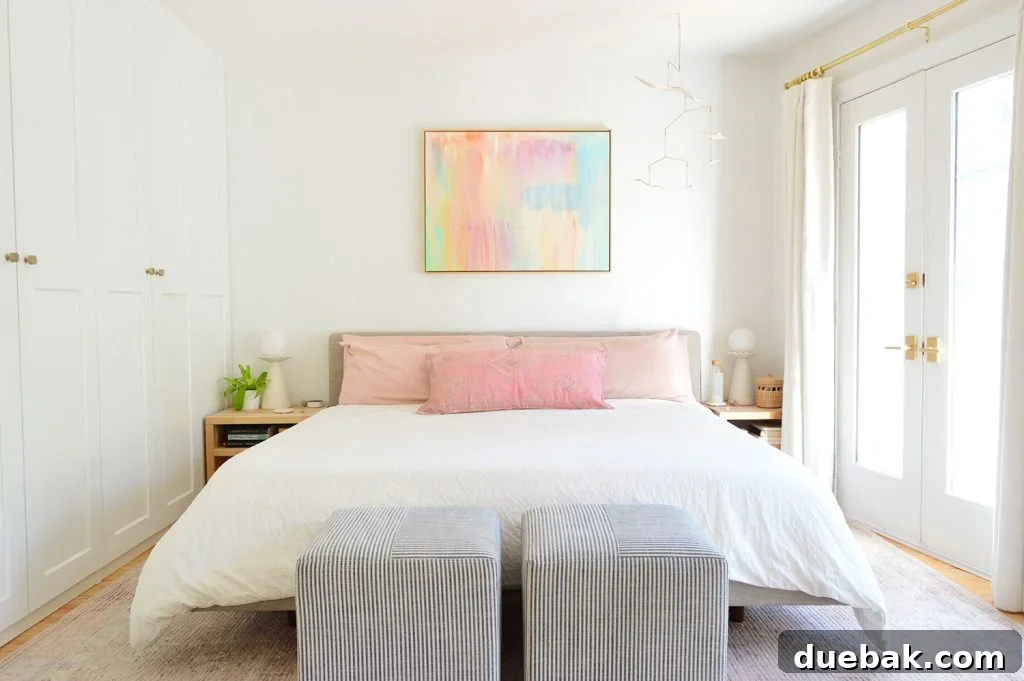 King Size Bed With White Bedding In Modern Bedroom With Striped Ottomans