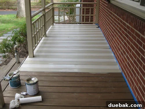 Mid-project view of painted deck planks with tan and cream stripes