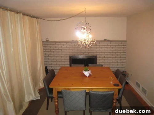 Dated dining room with wooden table and light walls before renovation, lacking a cohesive design.