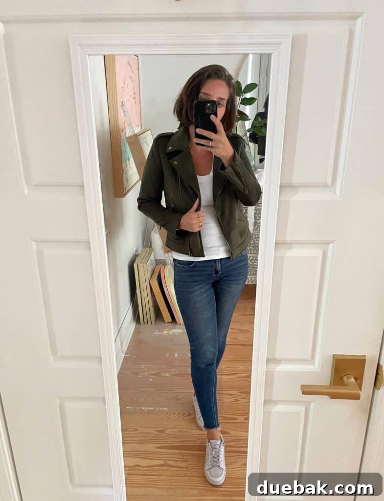 Parisian Chic Packing Secrets 20 Sherry selfie in mirror at home with white tank top and green jacket with jeans and tennis shoes