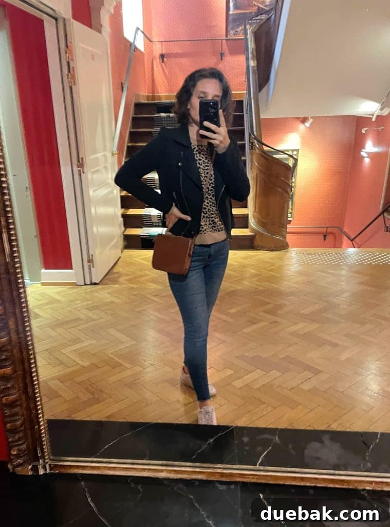 Parisian Chic Packing Secrets 27 Sherry selfie in hotel mirror with leopard sweater under black jacket and tennis shoes