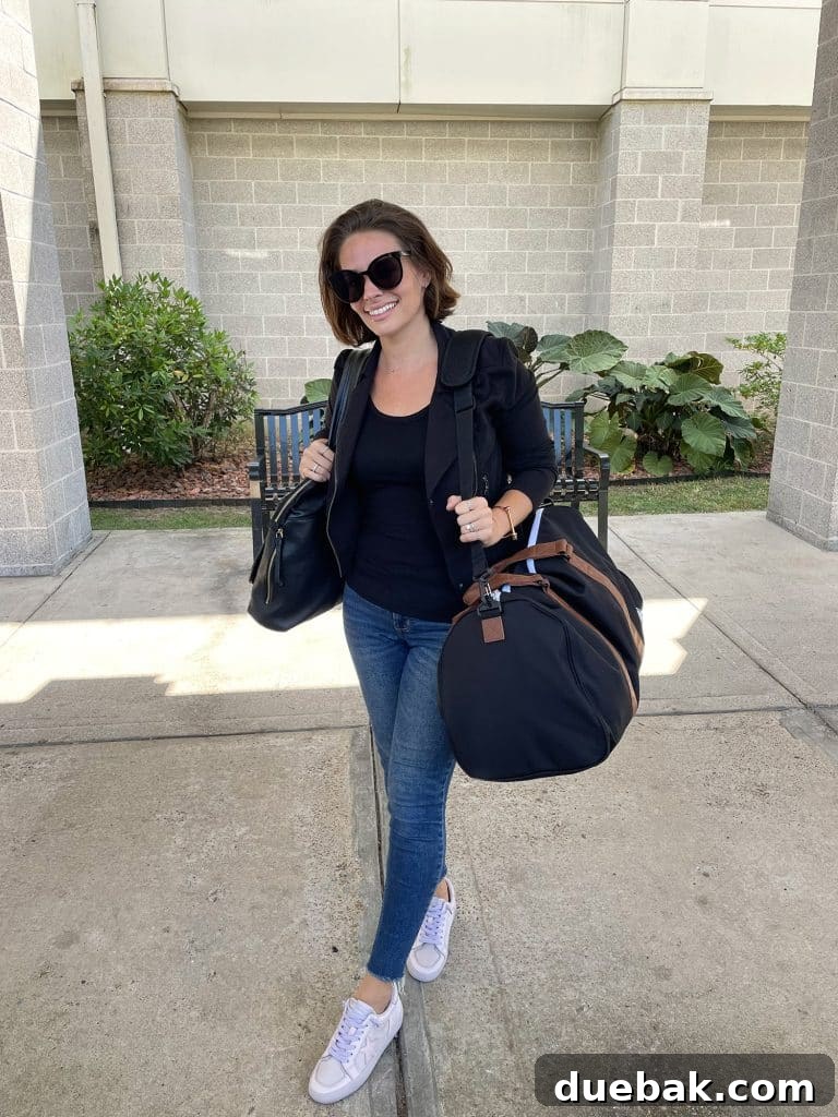 Parisian Chic Packing Secrets 30 Sherry with purse and duffel bag at airport with black jacket and black tank top and jeans