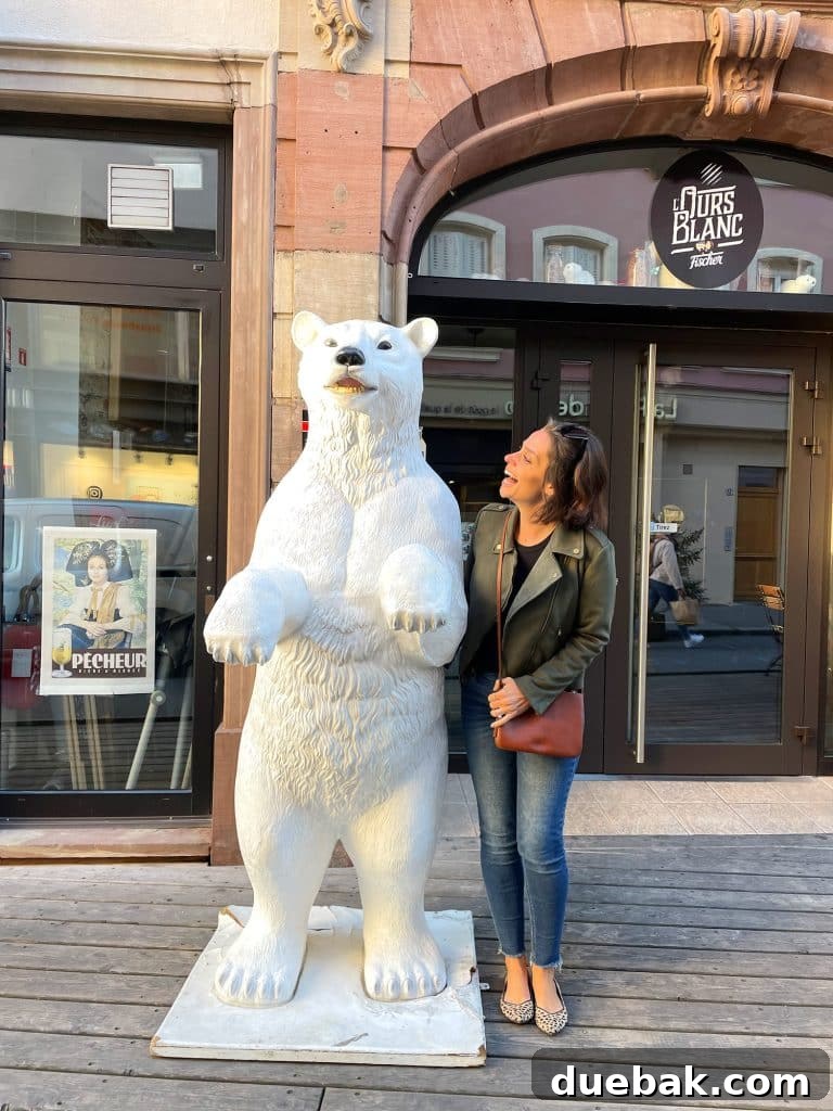 Parisian Chic Packing Secrets 33 Sherry posing with a polar bear statue with green jacket and black tank and jeans