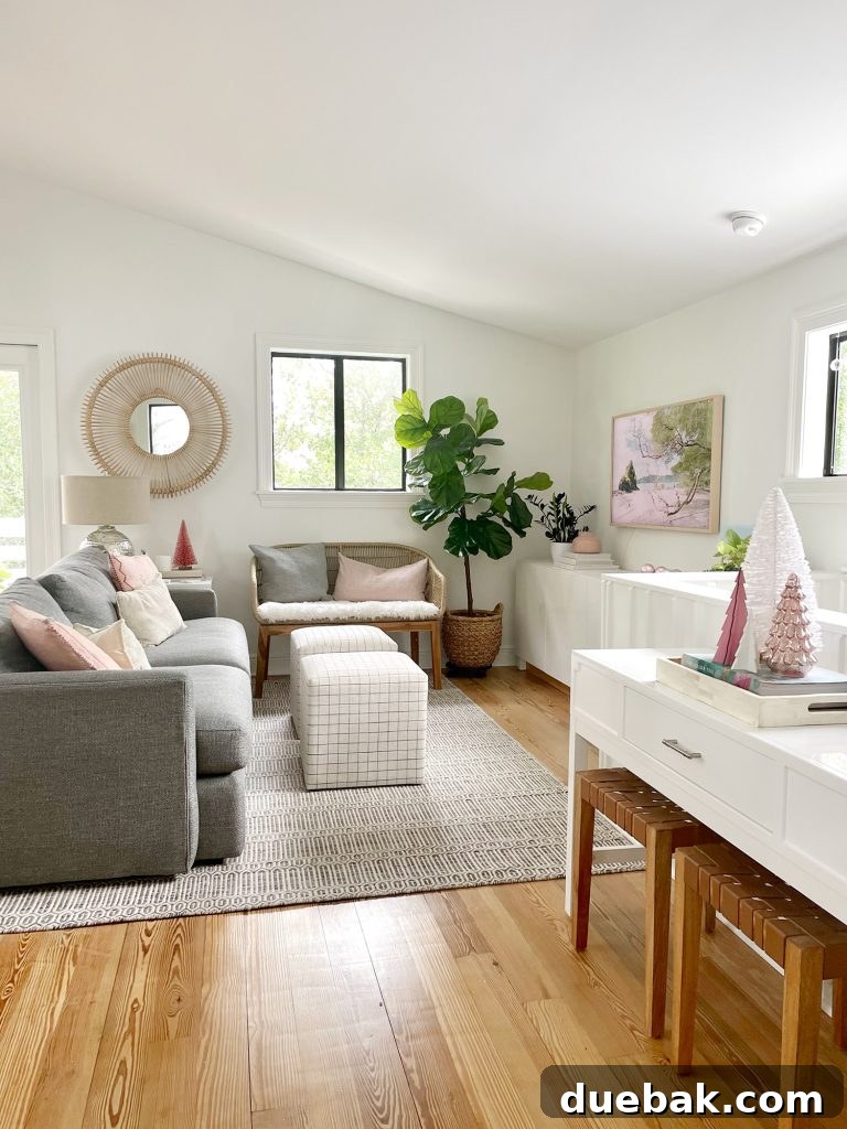 Joyful Simplicity: Our Holiday Edit 11 Angled view of a minimalist living room with a new sheepskin loveseat and elegant Christmas trees on tabletop