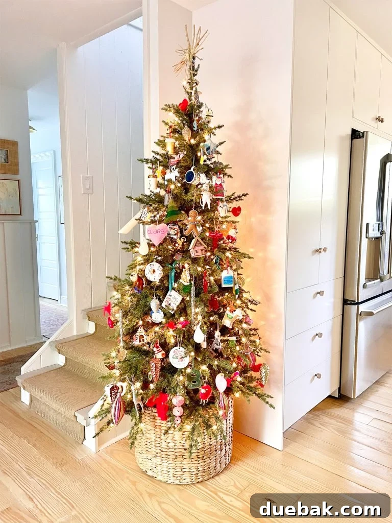 Joyful Simplicity: Our Holiday Edit 3 Narrow Christmas tree nestled in kitchen corner, next to pantry and stairs, enhancing holiday home decor