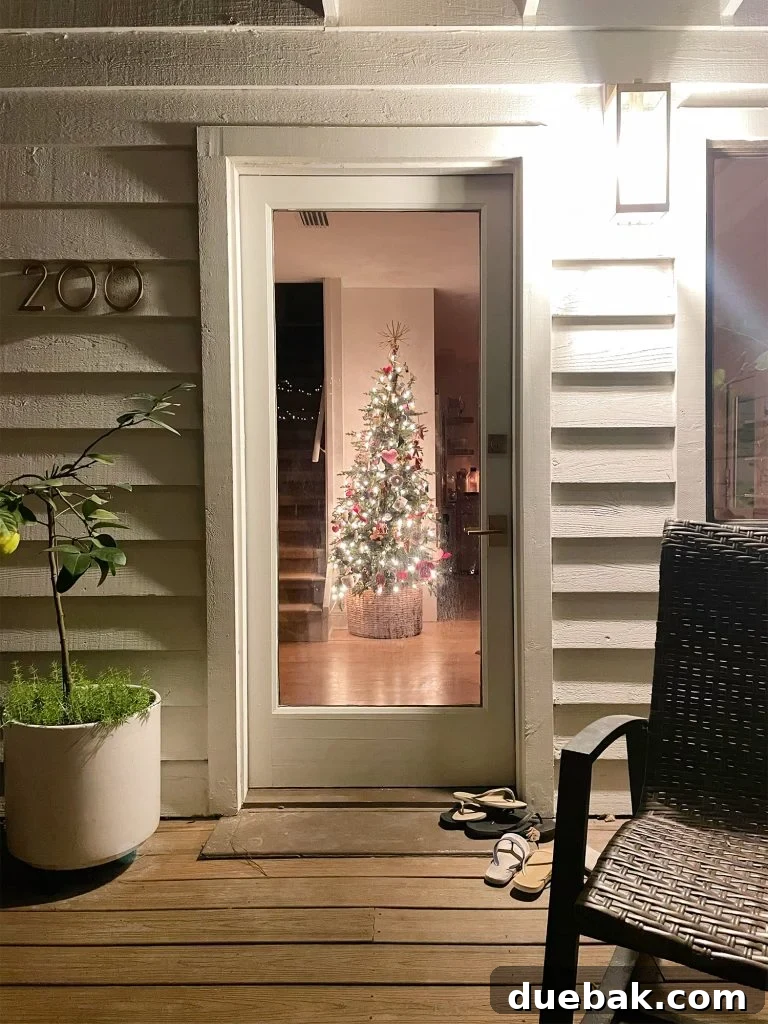 Joyful Simplicity: Our Holiday Edit 4 Glowing Christmas tree visible through front door at night, showcasing kitchen holiday decor