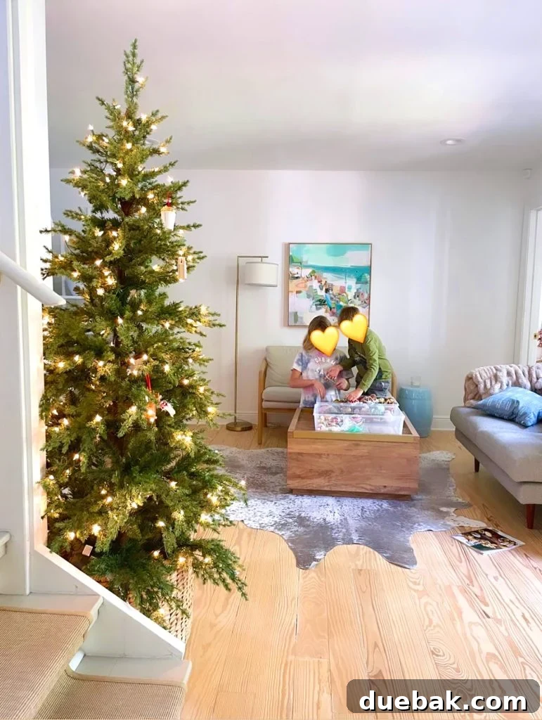 Joyful Simplicity: Our Holiday Edit 5 Children decorating an undecorated Christmas tree in the kitchen, highlighting family holiday traditions