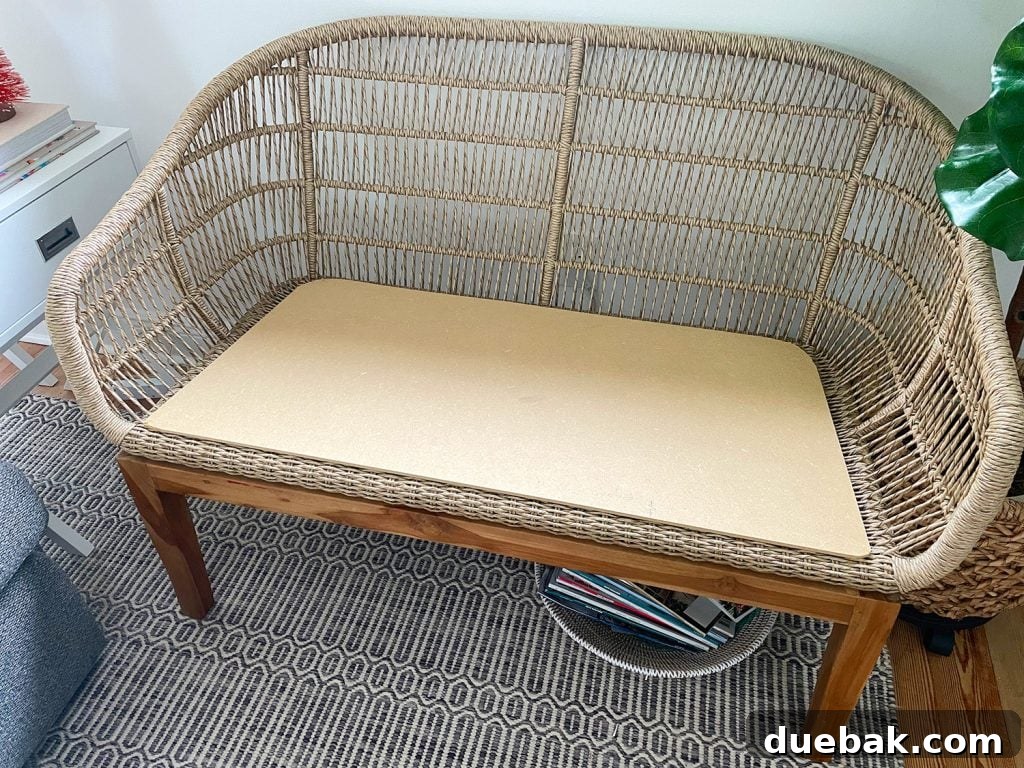 A natural woven jute loveseat base supporting a newly cut MDF platform, ready for upholstery, highlighting the perfect fit.