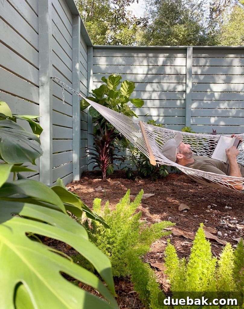 John Laying In Side Yard Hammock Amongst Tropical Plantings, enjoying a moment of peace.
