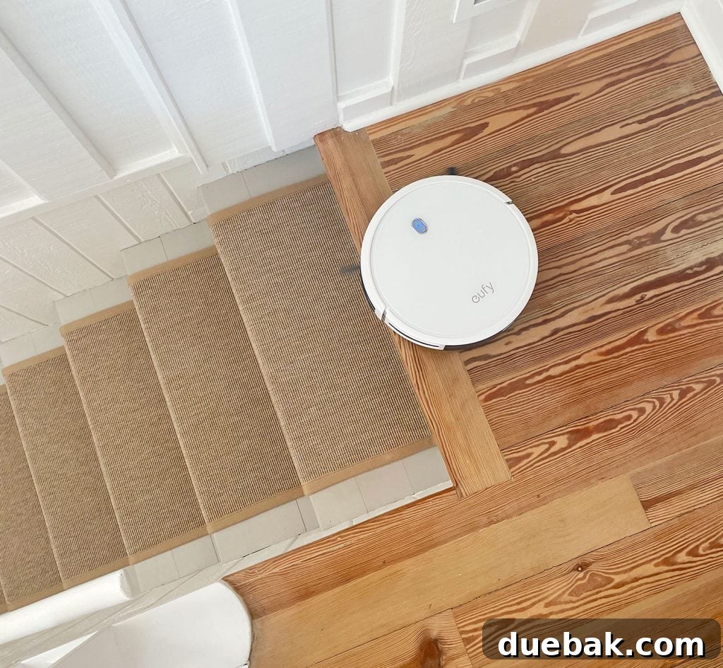 Eufy RoboVac 11S Max vacuuming safely at the top of a staircase, demonstrating its cliff sensors