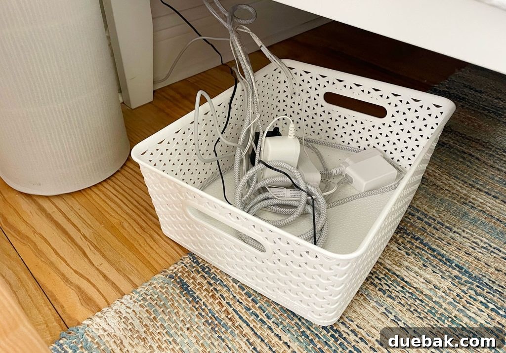 Low bin full of organized wires and cords neatly tucked under a bed frame
