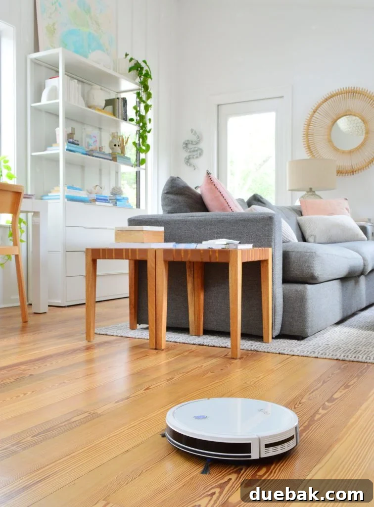 Eufy RoboVac 11S Max robot vacuum cleaning the wood floor of an upstairs family room
