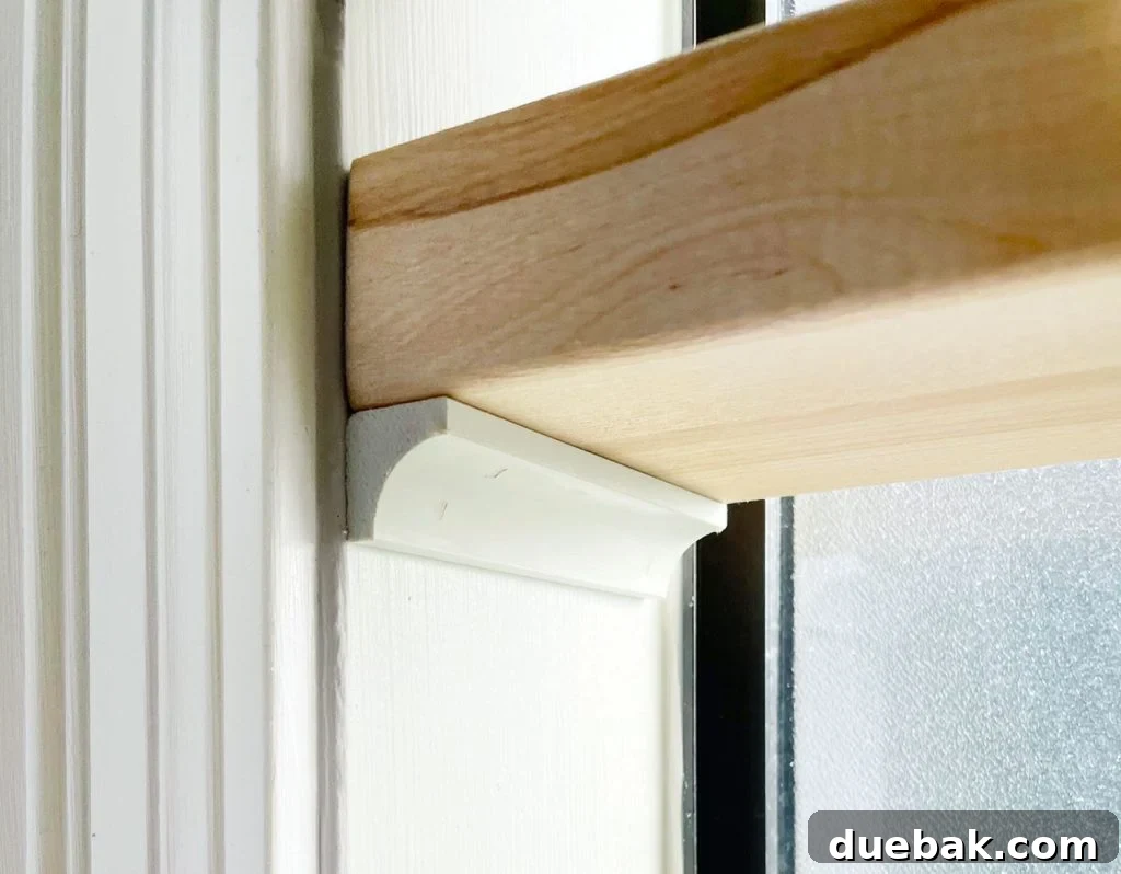 Close Up Of Butcher Block Shelf Propped Up On Cove Molding In Bathroom Window