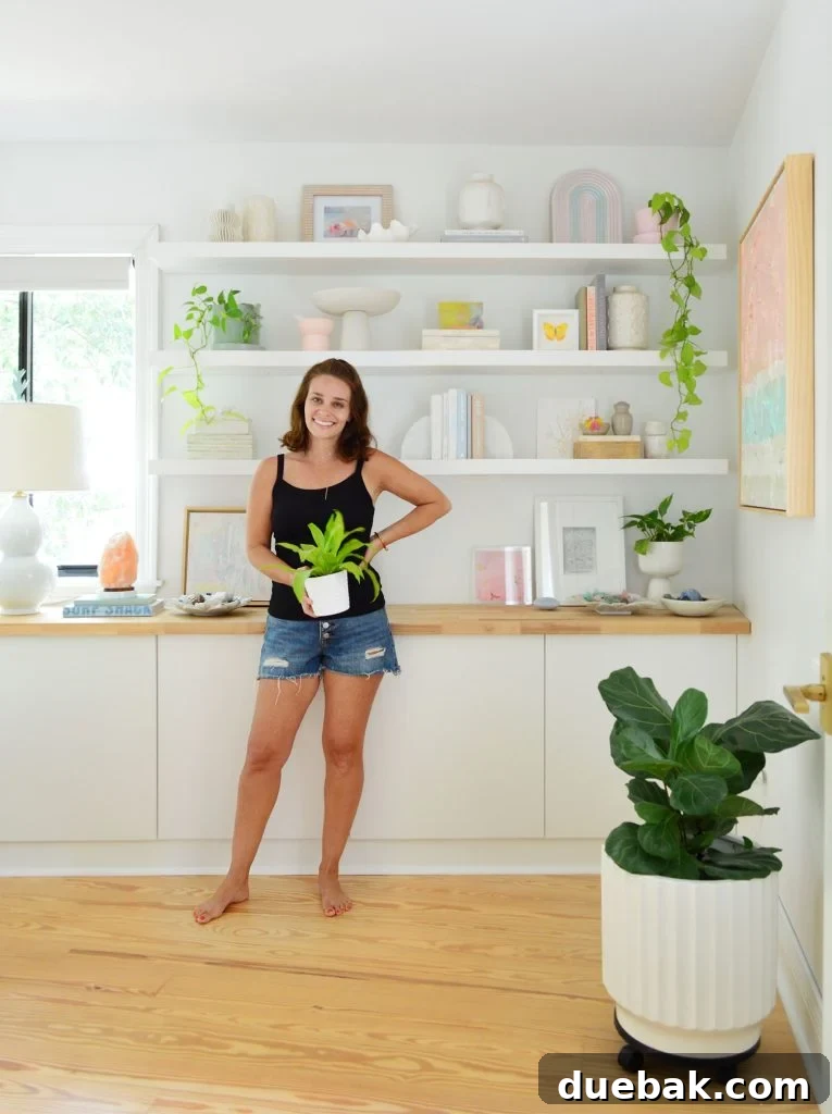 Sherry Standing With Plant In Front Of Ikea Lack Floating Shelves