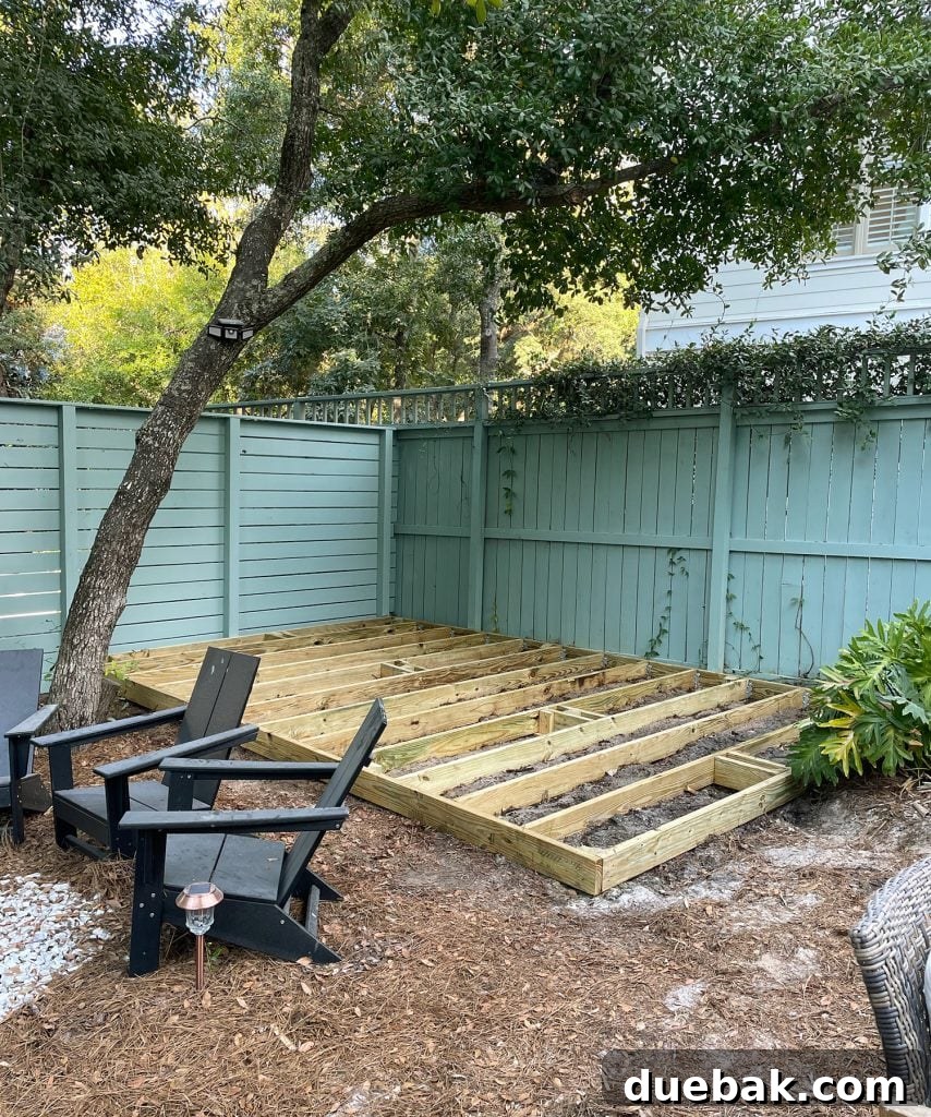 Deck Platform Under Construction In Backyard With Green Fence