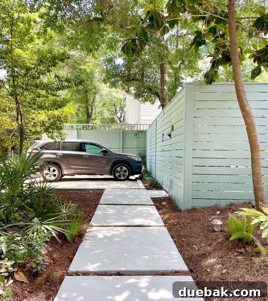 Gray SUV parked in gravel driveway parking spot with concrete walkway sidewalk