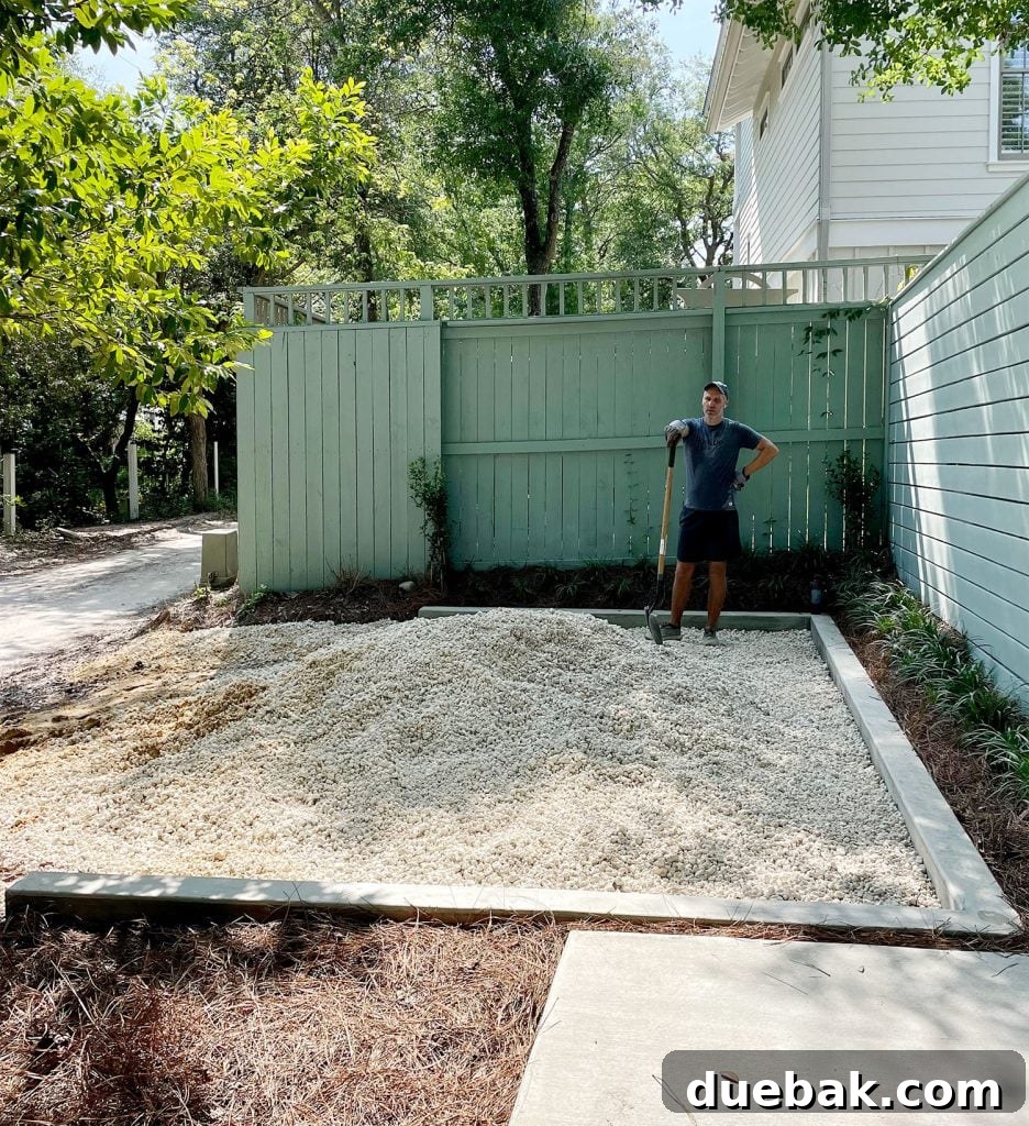 John with shovel spreading pile of bahama rock in driveway parking spot