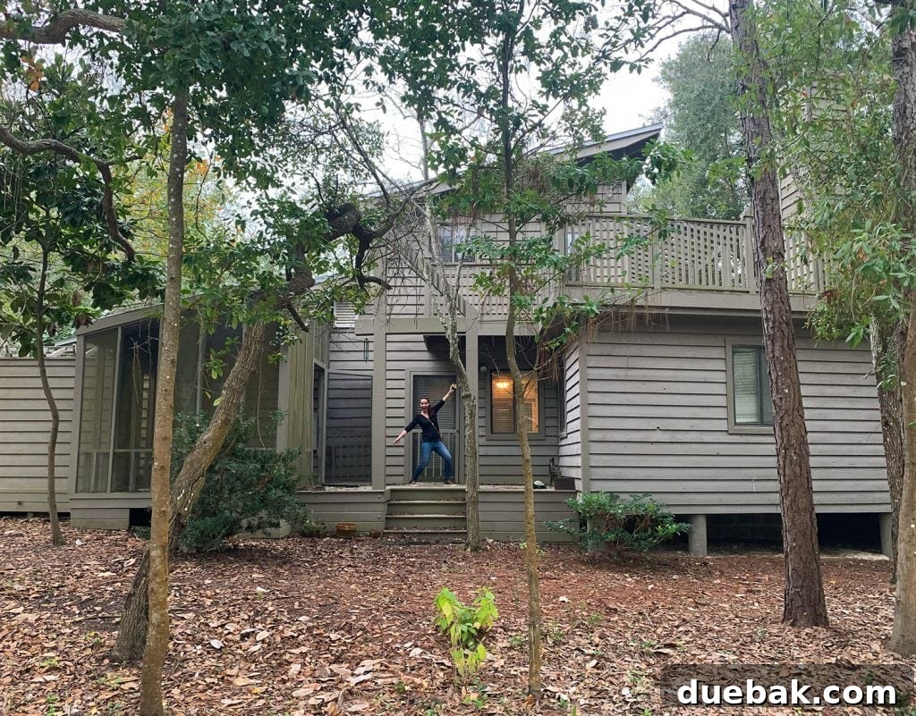 Before photo of home with brown siding and leaf covered dirt yard