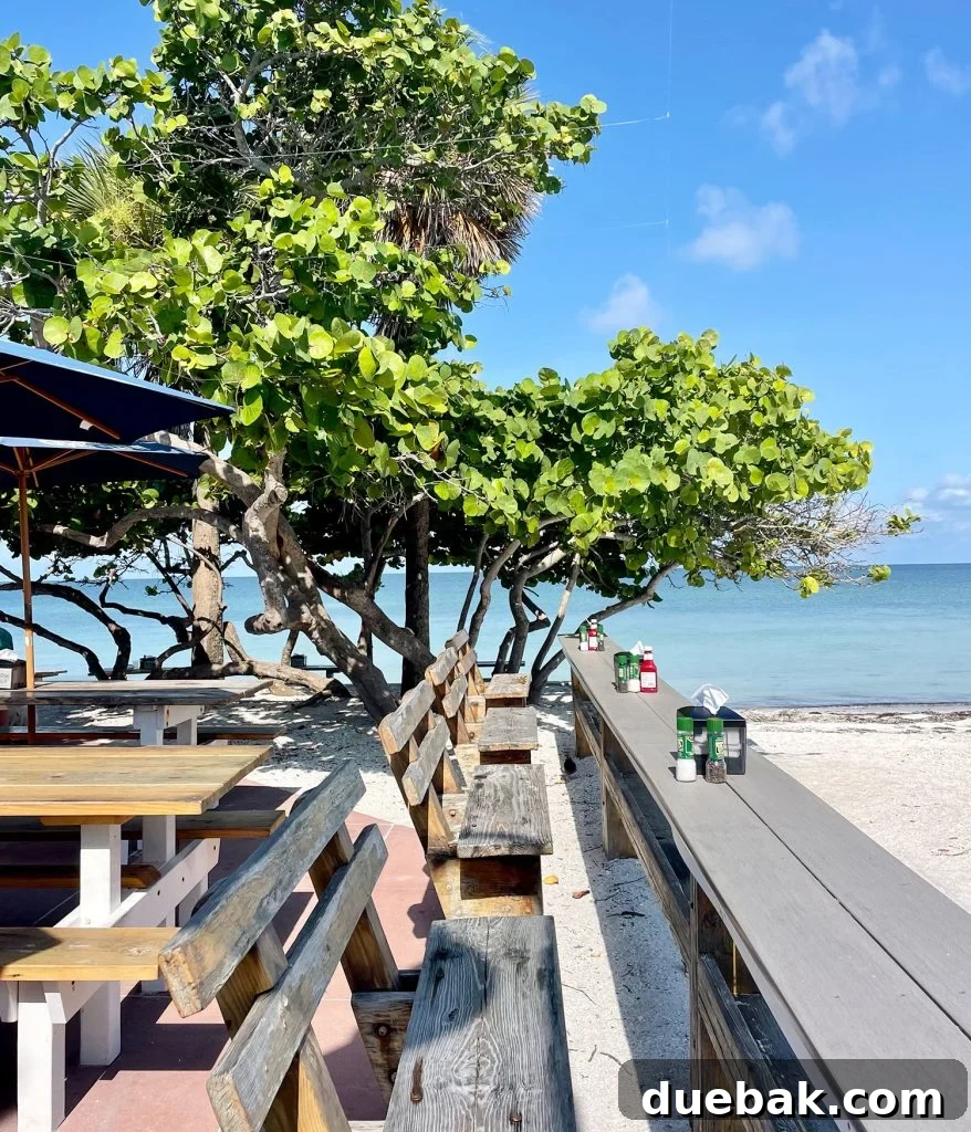 The idyllic beachfront setting of Paradise Grille in Passe-A-Grille, Florida, with tables directly on the sand.