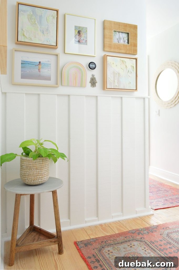 White hallway with wainscoting and picture frame collage and turkish runner rugs
