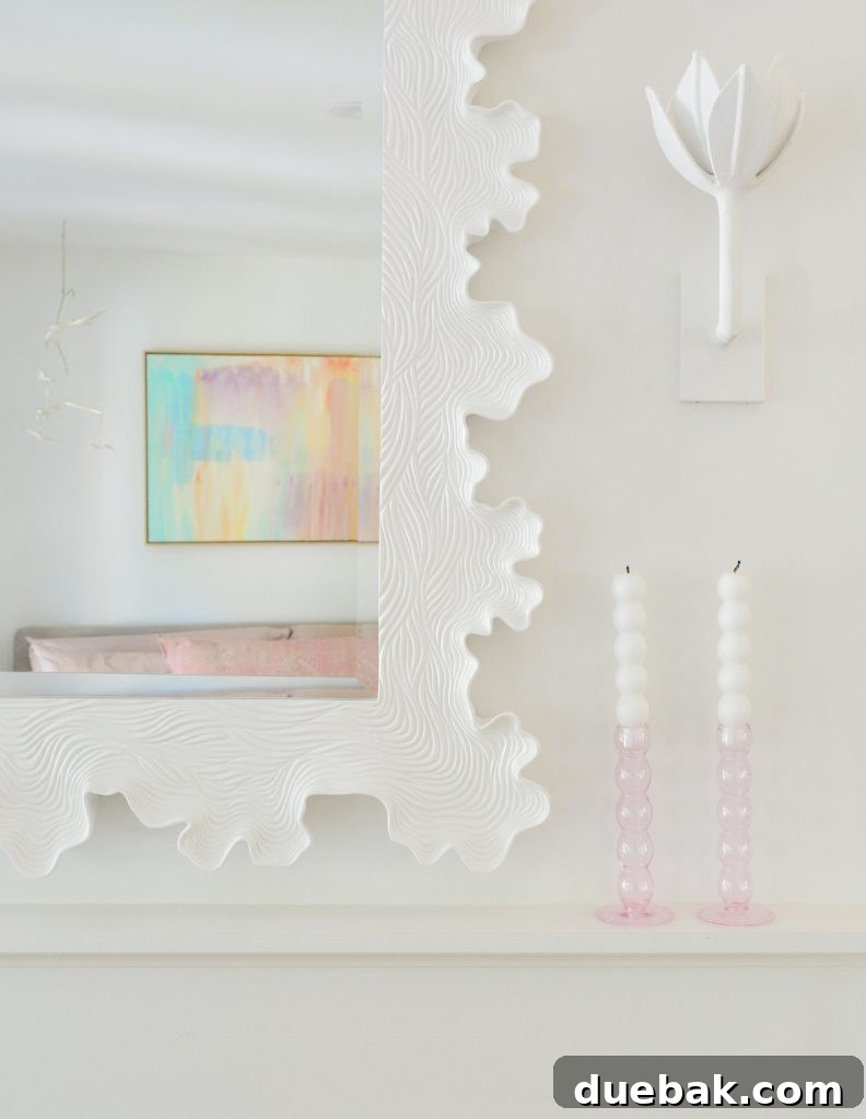 6 Clever Ways We Elevated Our Bedroom 18 Close-up detail of a white sculptural clamshell scalloped mirror elegantly placed above the fireplace