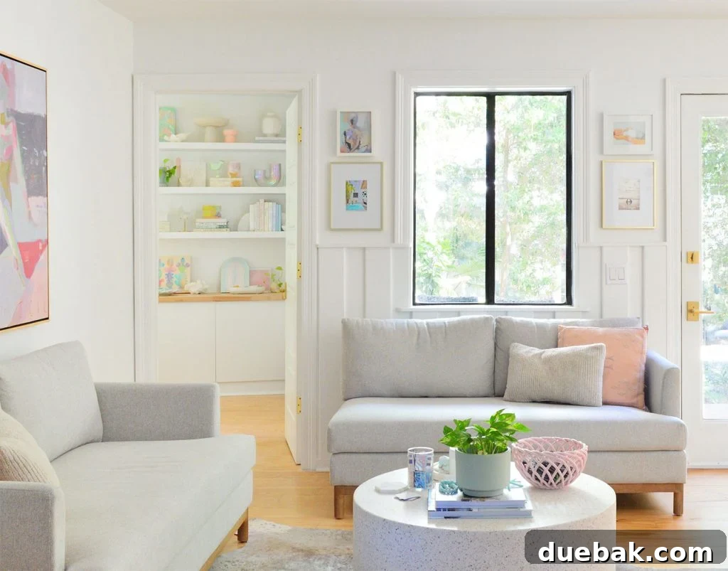 6 Clever Ways We Elevated Our Bedroom 27 Cozy sitting area with loveseats and a doorway leading into the bedroom, revealing colorful, styled shelves