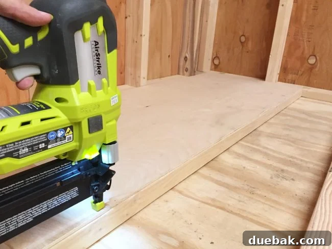 Nailing plywood panel onto the bottom level of the scrap wood storage organizer
