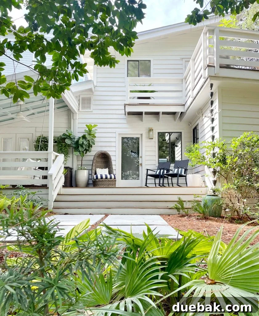 Sherwin Williams Pure White SW 7005 The Ultimate Whole House White 10 Exterior of a modern white home with siding and Florida landscaping, painted in a softer white for outdoors.