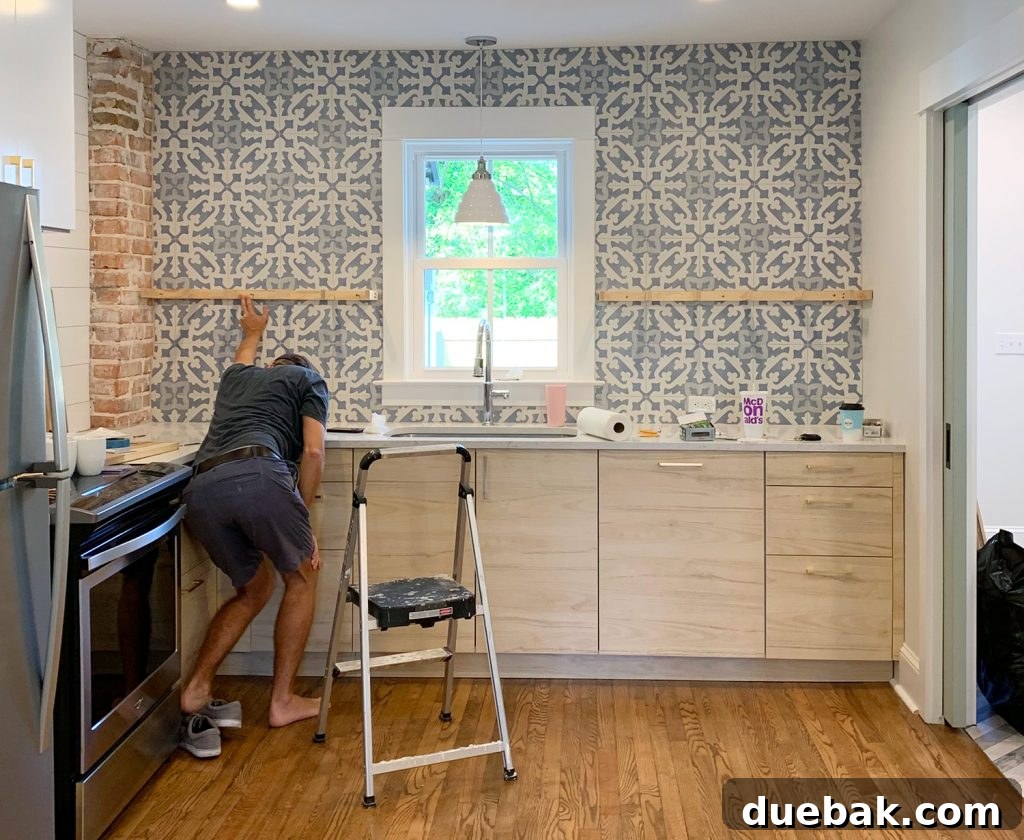 Elevate Your Kitchen with DIY Floating Shelves 8 Man Crouching and Holding a Kitchen Floating Shelf Bracket Against Tile for Precise Placement