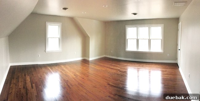 Crafting Custom Built-In Cabinetry 3 Wide angle panoramic photo of an empty bonus room with tan walls, wood floor, windows, and a recessed niche, awaiting built-in transformation
