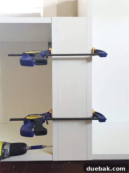 Crafting Custom Built-In Cabinetry 7 Step-by-step guide showing how to add initial filler pieces between Ikea cabinets using clamps and screws for a seamless built-in look