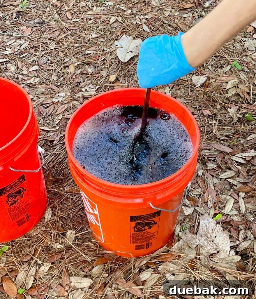 Mastering Fabric Dyeing at Home 12 Hand Stirring Bucket Of Black Rit Fabric Dye With Clothes Inside