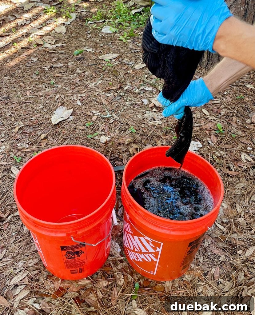 Mastering Fabric Dyeing at Home 13 Squeezing Out Excess Fabric Dye From Black Sweater Over Bucket