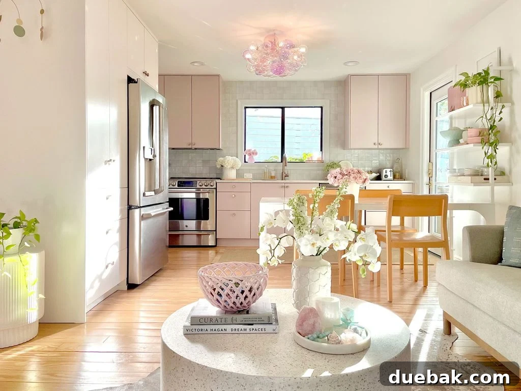 Small, stylish IKEA kitchen with mauve cabinets and a cozy seating area with a terrazzo coffee table, maximizing space