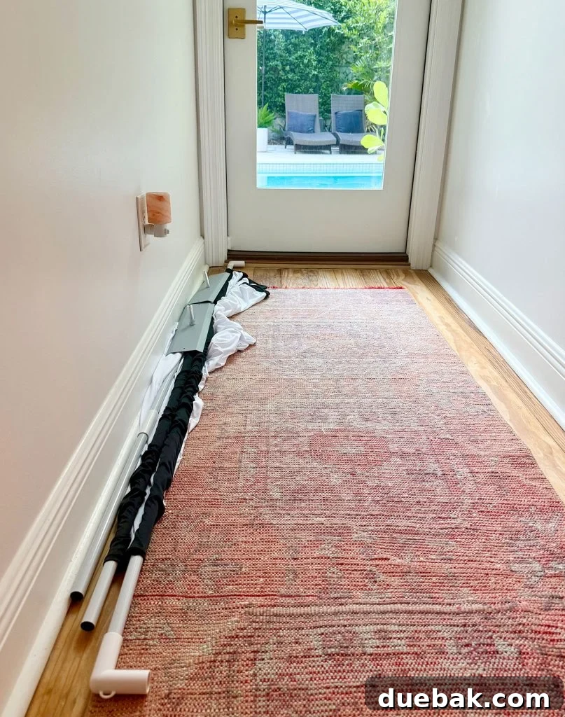 Outdoor Movie Screen Broken Down And In Hallway - The collapsed outdoor movie screen components neatly stored in their carrying bag.